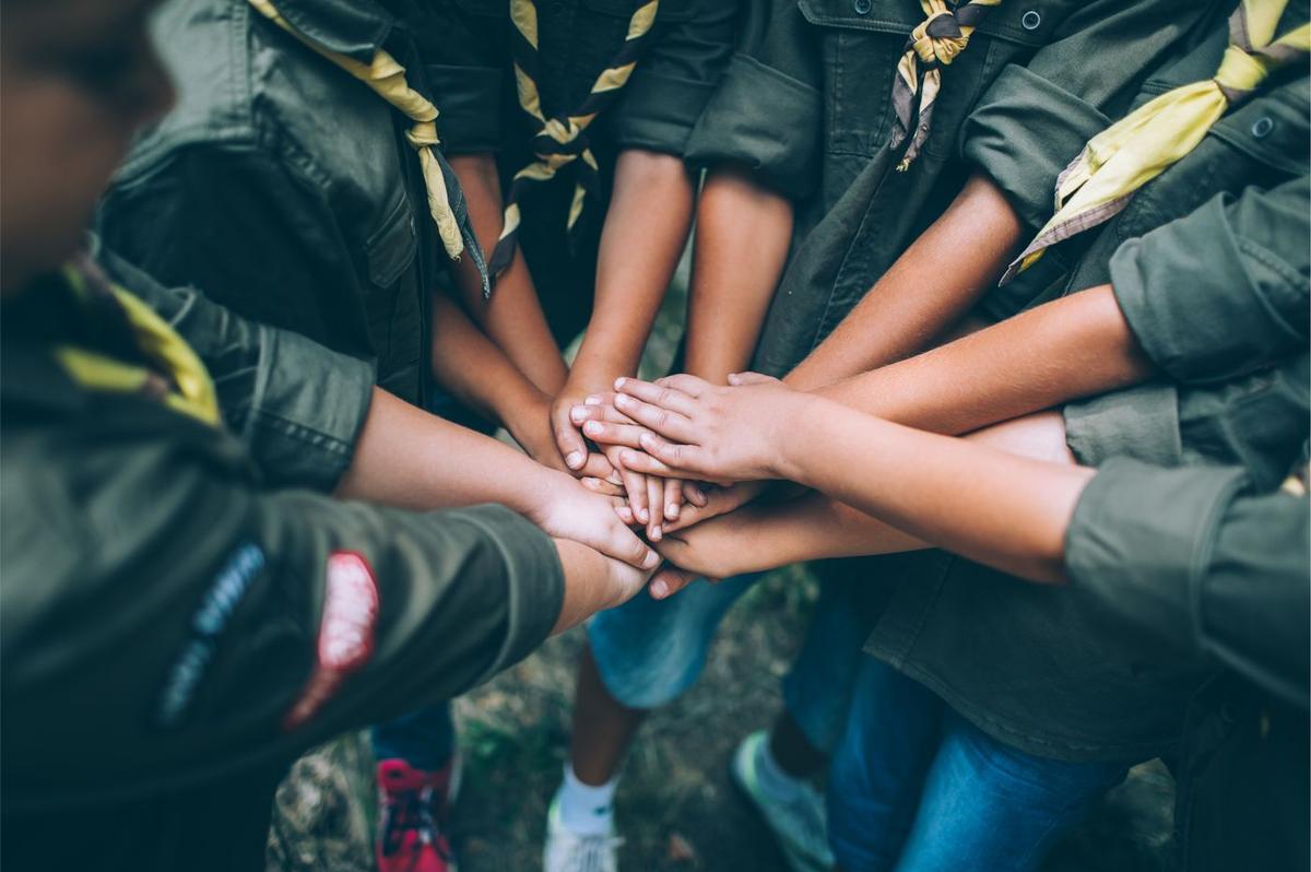 A group of Scouts stacking their hands together